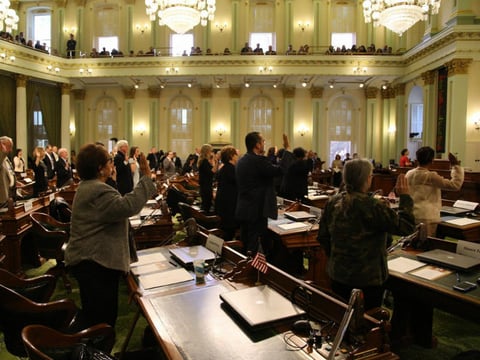 California electors stand for swearing in at the state capitol on December 19, 2016.